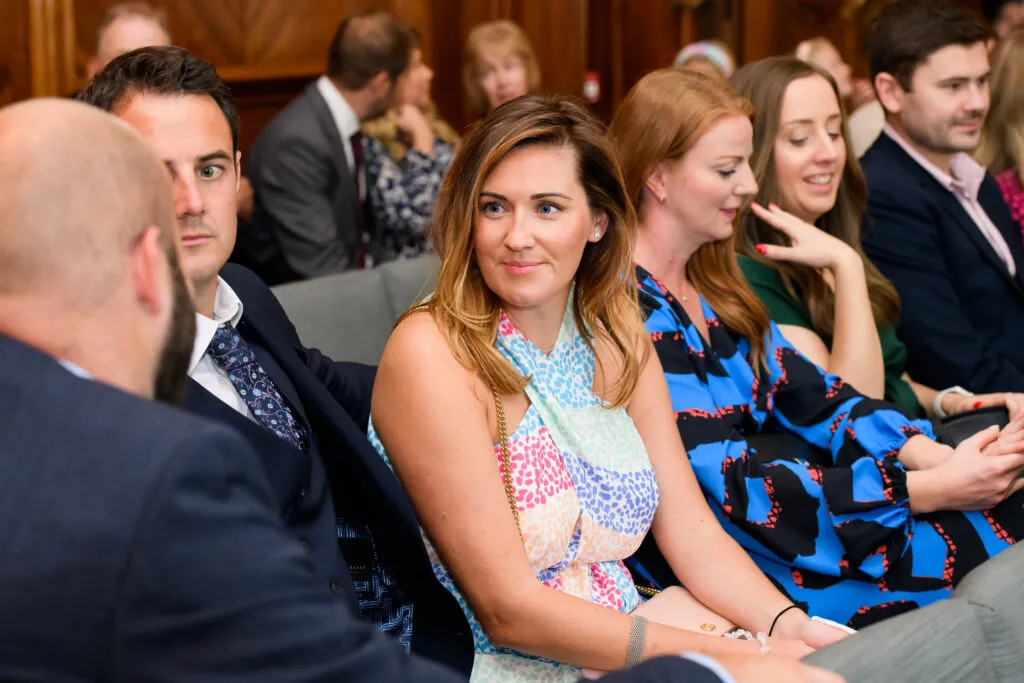Candid photo of female guest sat during wedding ceremony