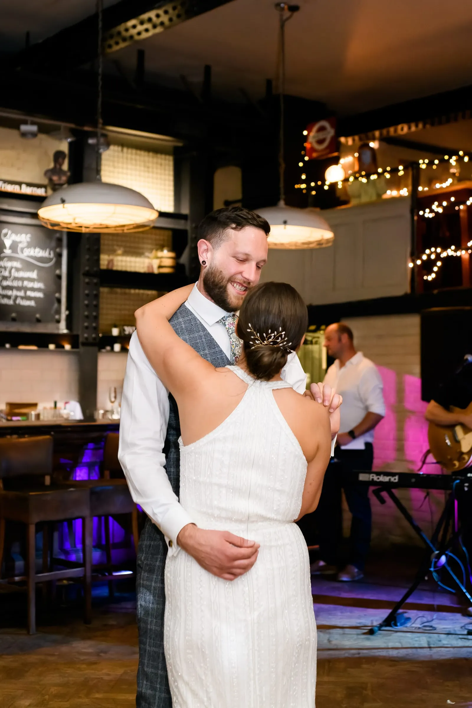 Bride and groom laughing during their first dance in London pub venue