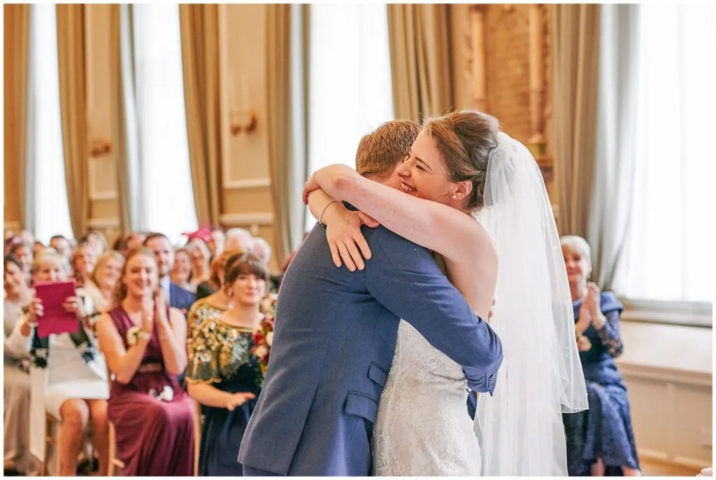 Bride and groom hugging during their London wedding ceremony at the Beaumont Estate