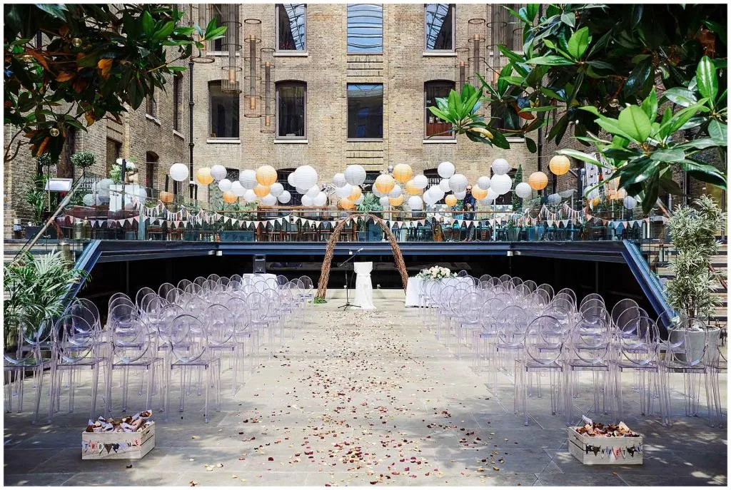 Empty wedding ceremony set up with colourful lanterns and chairs at Devonshire Terrace courtyard