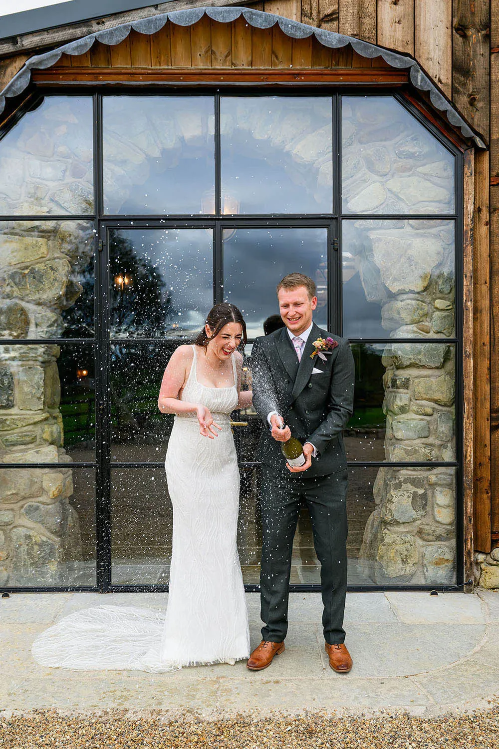Wedding couple spraying champagne at Willow Marsh Farm in Nottingham