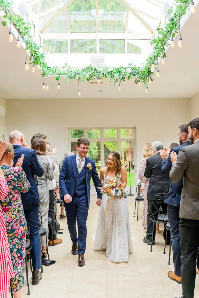 bride and groom walking down aisle after ceremony woodborough hall wedding