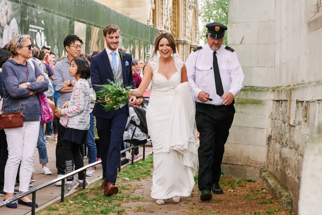 Bride and groom being escorted by a police man in central London. 