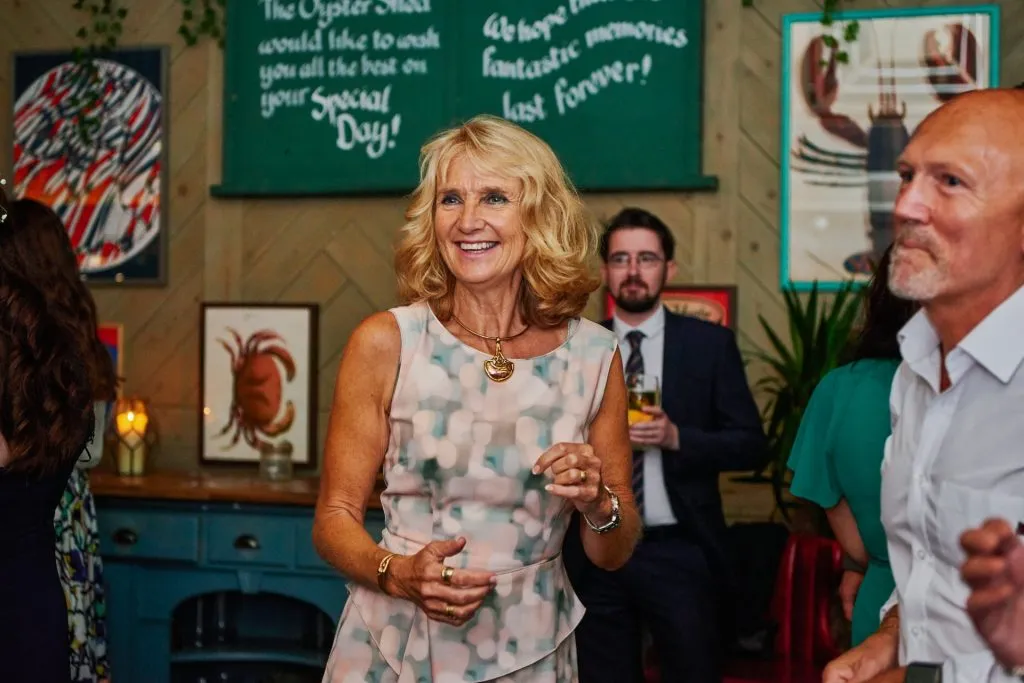 female guest laughing and dancing  at The Oyster Shed wedding venue 