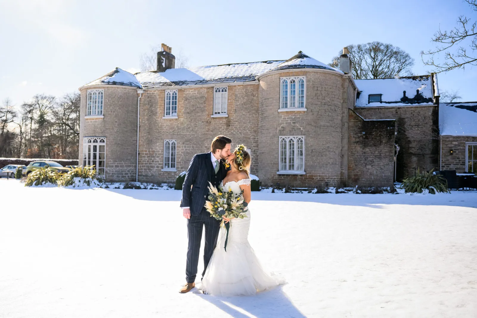 bride and groom kissing in front of cockliffe country house on their wedding day