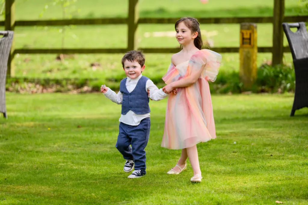 children walking together in the gardens during woodborough hall wedding reception