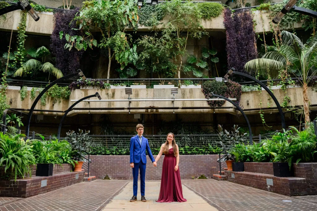 Couple holding hands during engagement photoshoot inside The Barbican Conservatory