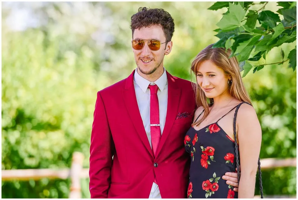 Candid photography showing happy wedding guests in front of rustic forest background