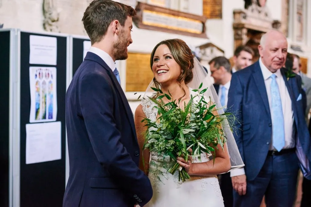 Bride and groom smiling at each other after their wedding ceremony. 