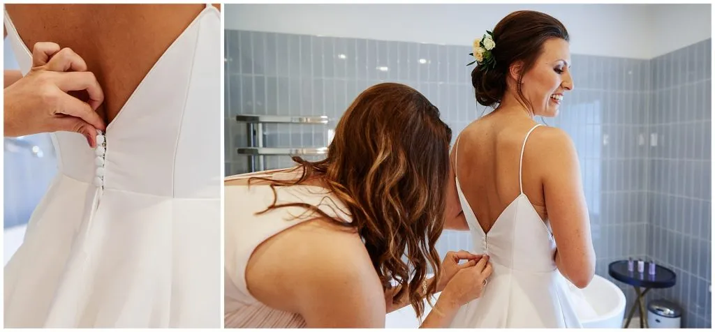 bride having her dress done up by her bridesmaid during bridal prep
