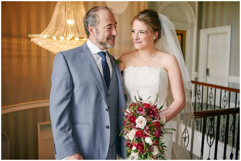 Bride with her dad on top of the staircase at the Beaumont Estate in Windsor