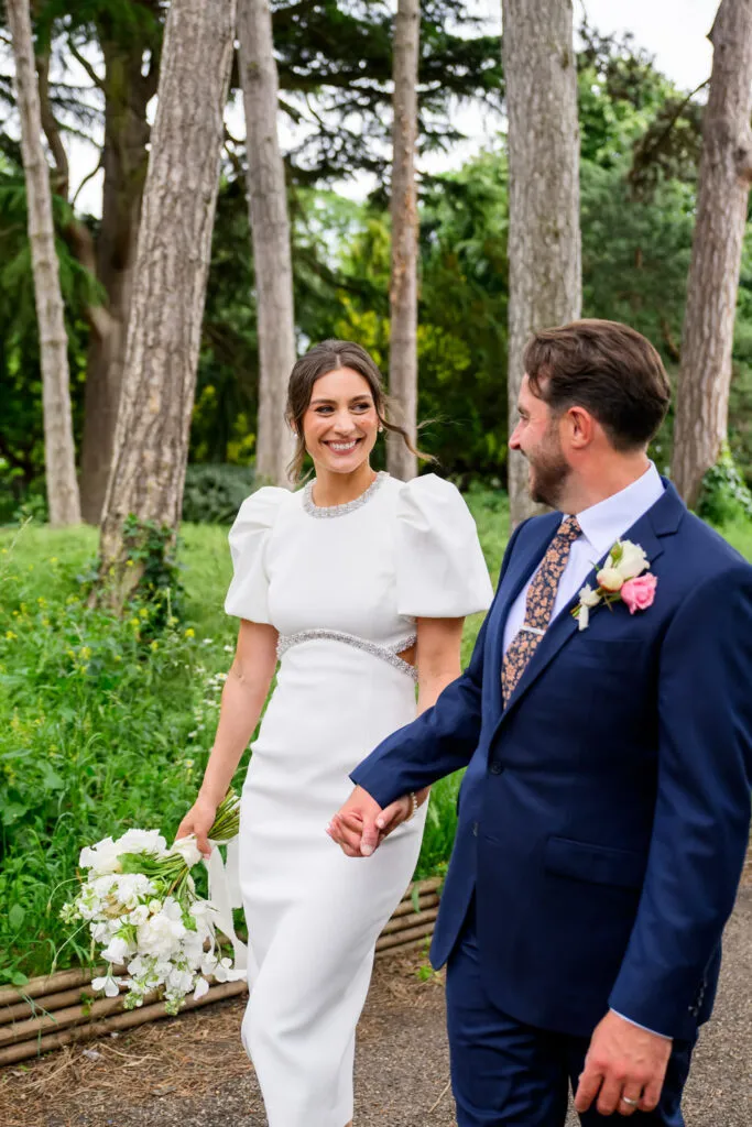 Bride and groom holding hands during wedding photos in West Bridgford Park
