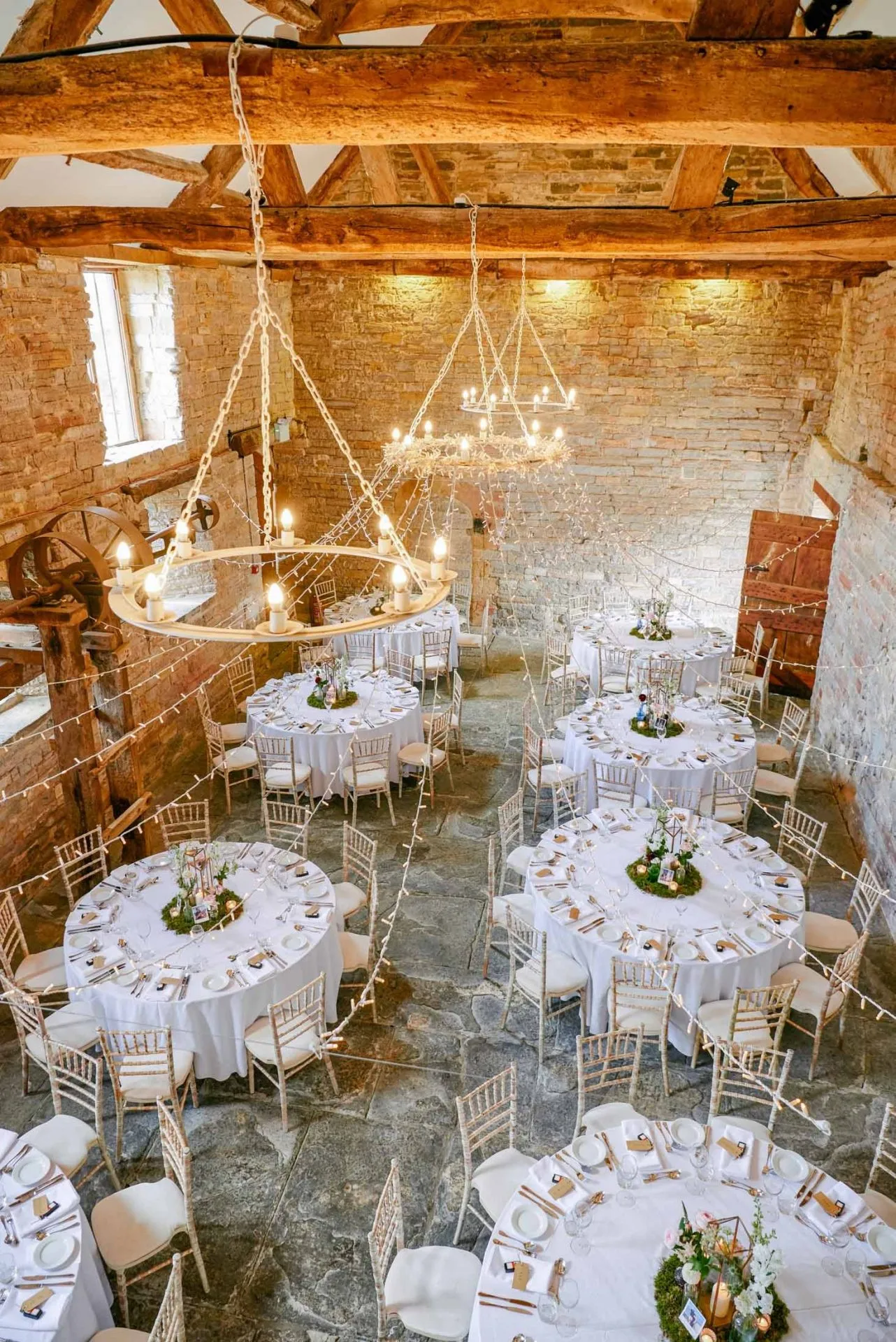 old rustic wedding venue with white round tables set up