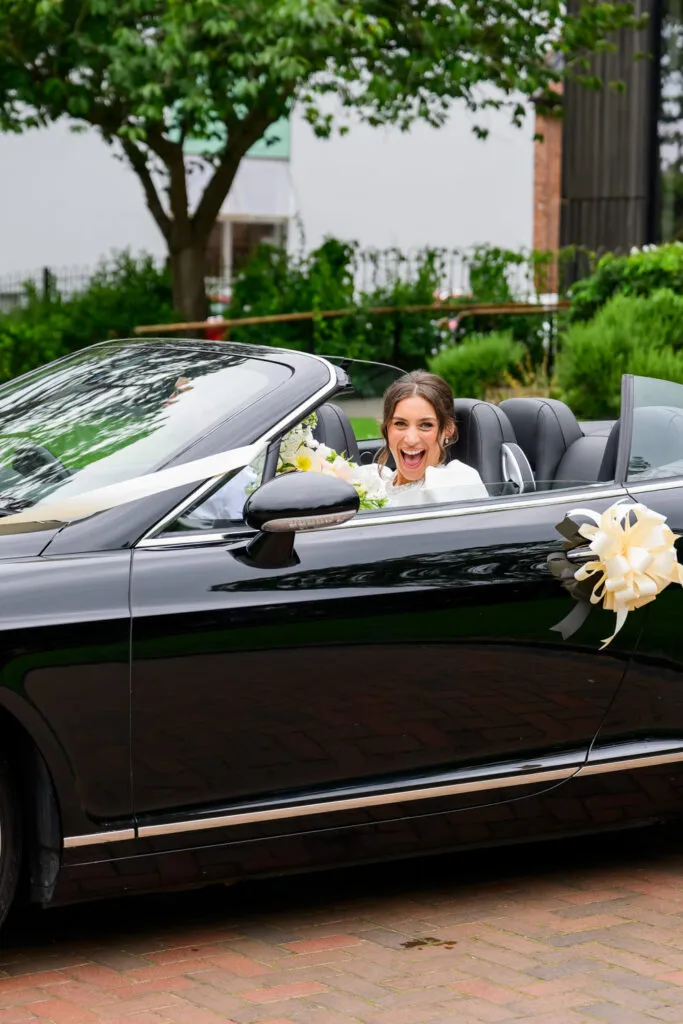 Bride sitting in a Bentley wedding car in West Bridgford park