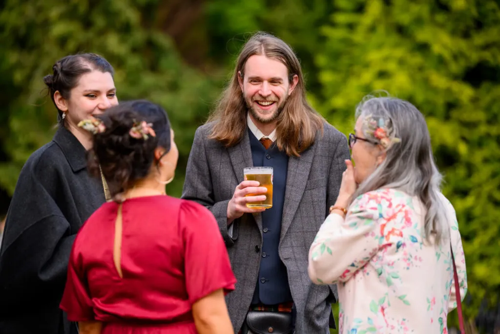 friends chatting with drinks during woodborough hall wedding reception