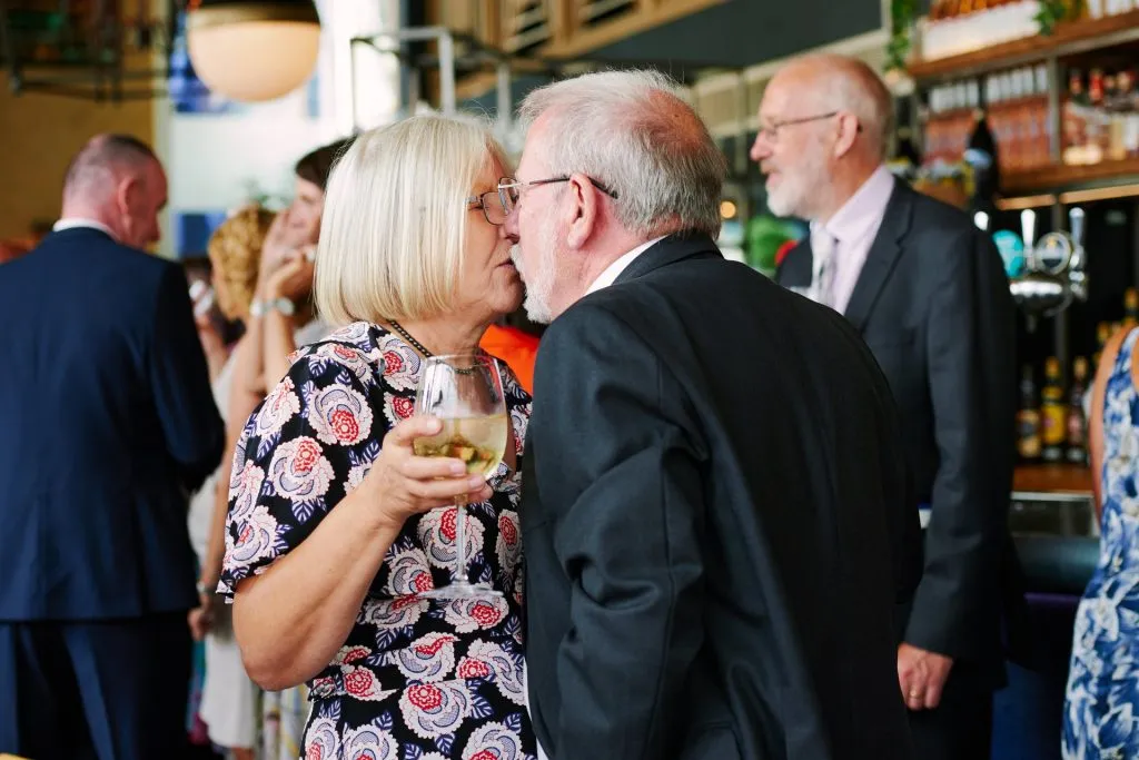 Old couple kissing whilst at a wedding reception at The Oyster Shed 