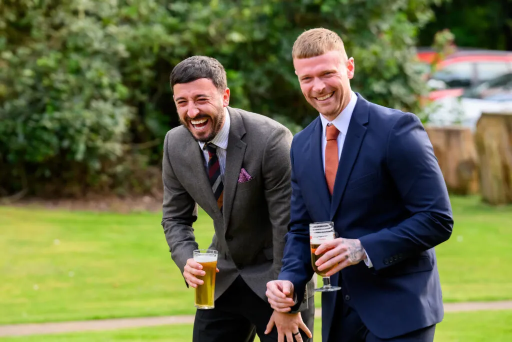 guests laughing during outdoor drinks reception at woodborough hall wedding