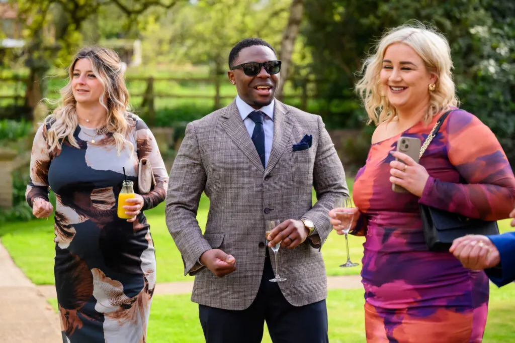 wedding guests walking through the gardens during drinks reception at woodborough hall