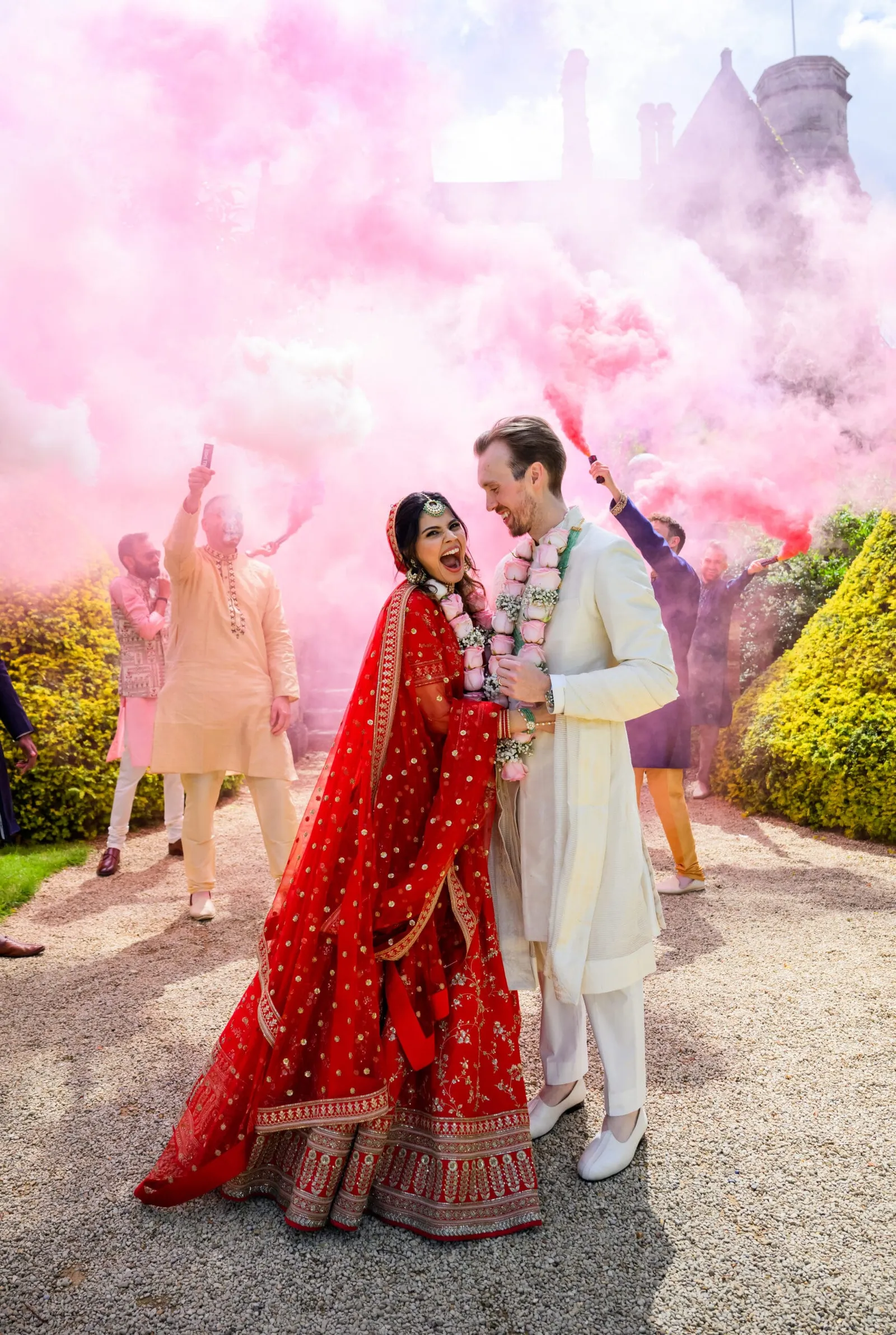 Bride and groom surrounded by colourful and vibrant smoke bombs