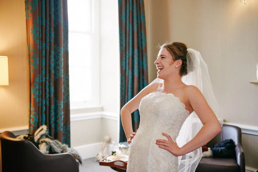 bride laughing in her wedding dress during bridal prep
