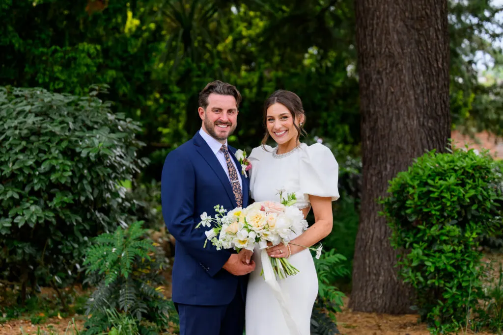 Bride and groom portrait in West Bridgford Park in front of green trees