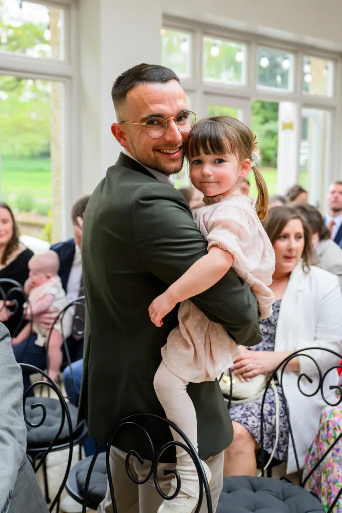 wedding guest holding child during ceremony woodborough hall
