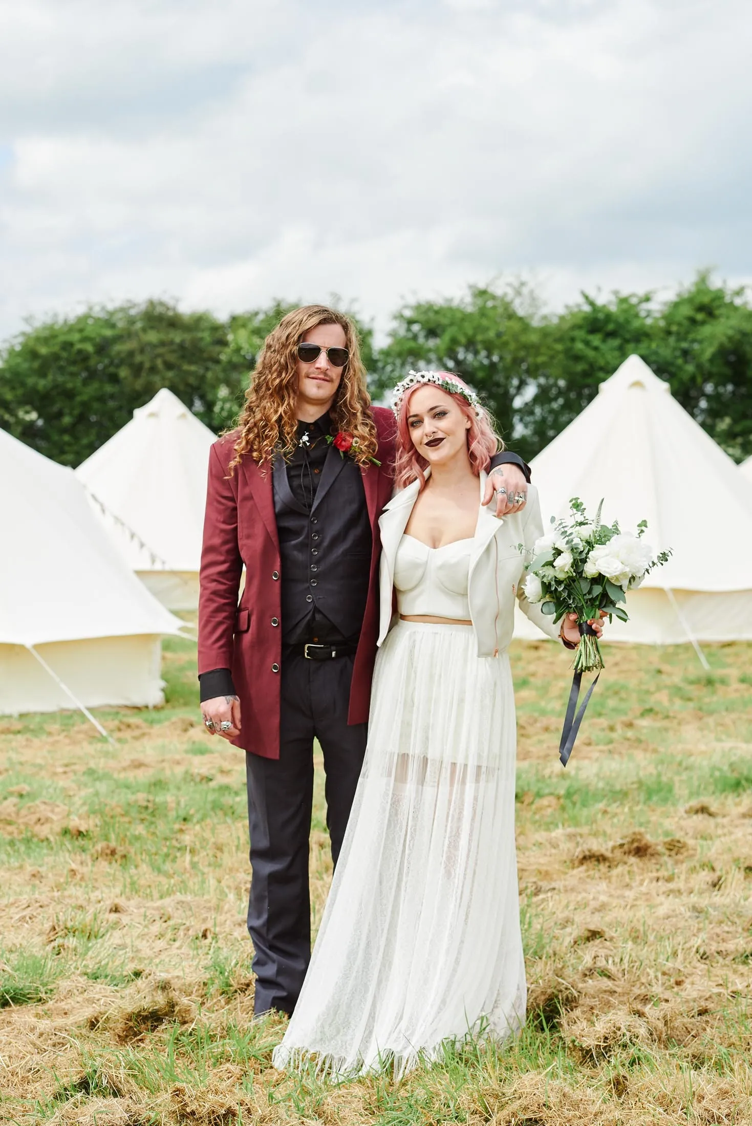 Alternative Bride and groom stood in front of festival tipis at The Peasantry Brewery