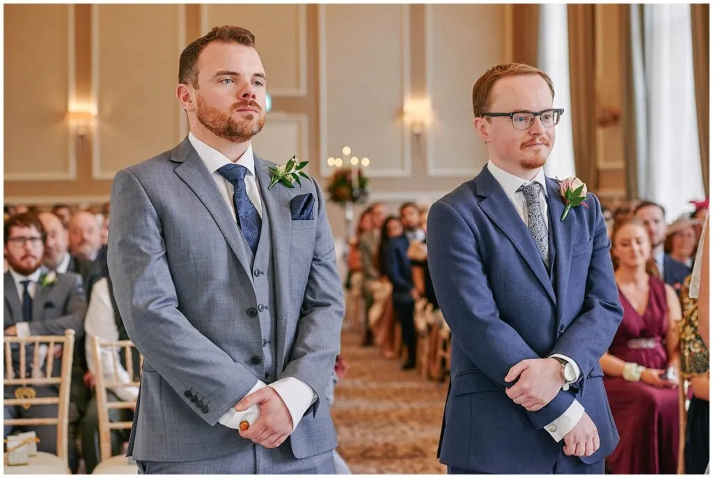 groom and his best man waiting at the end of the alter during wedding ceremony