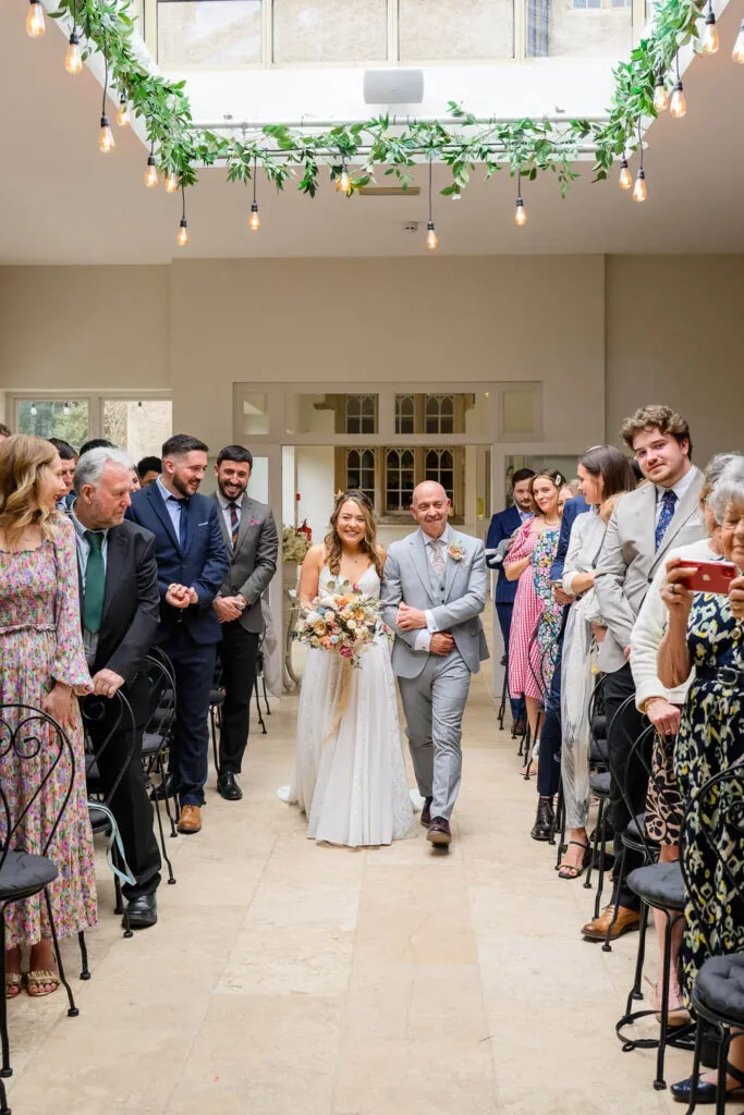 bride walking down aisle in orangery ceremony woodborough hall wedding