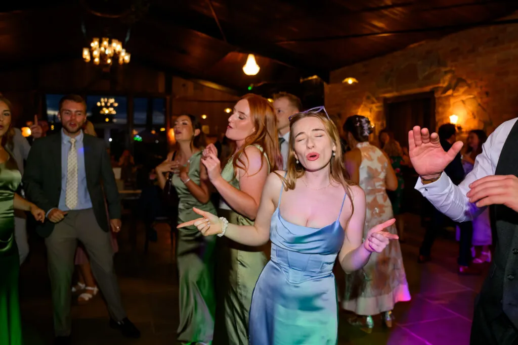 Wedding guests dancing together on the dancefloor during evening reception