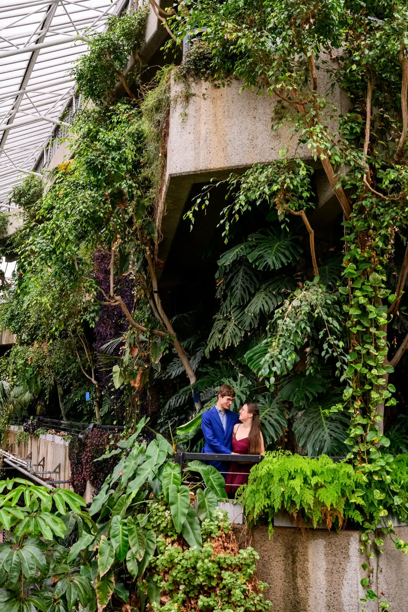 Couple stood on balcony during wedding photoshoot inside The Barbican Conservatory