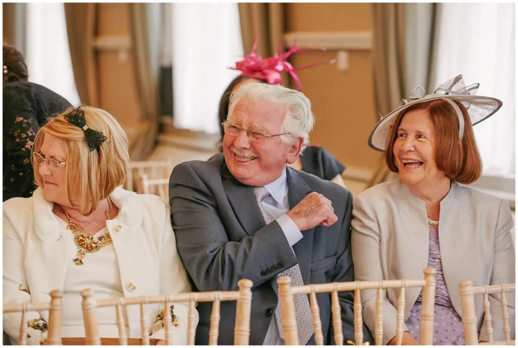 Old guest laughing during London wedding ceremony at the Beaumont Estate