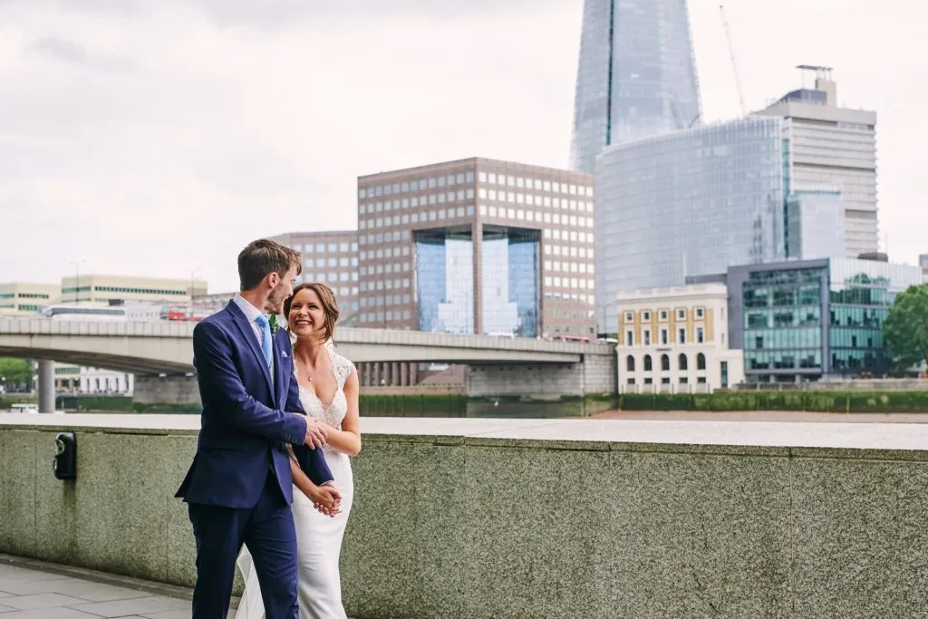 Wedding couple walking along the riverside in front of The Shard in London