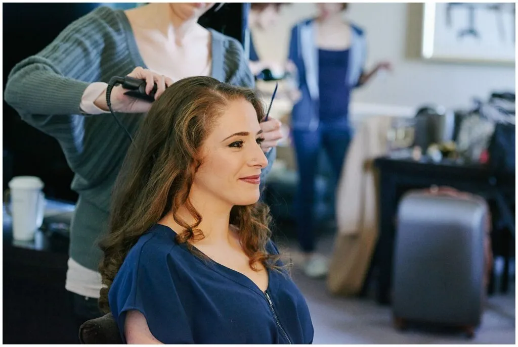bride having her hair styled during bridal prep