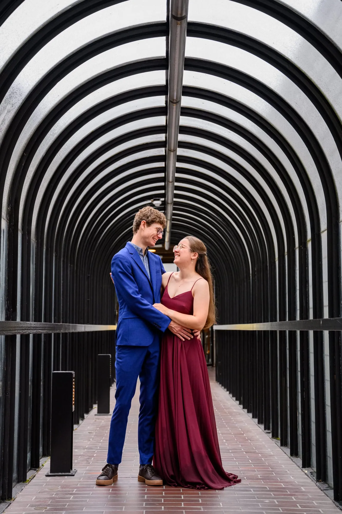 couple smiling together whilst stood in a tunnel walkway at The Barbican Centre