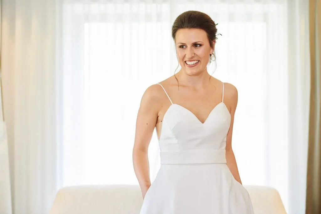 Bride in her wedding dress and smiling in hotel room in London