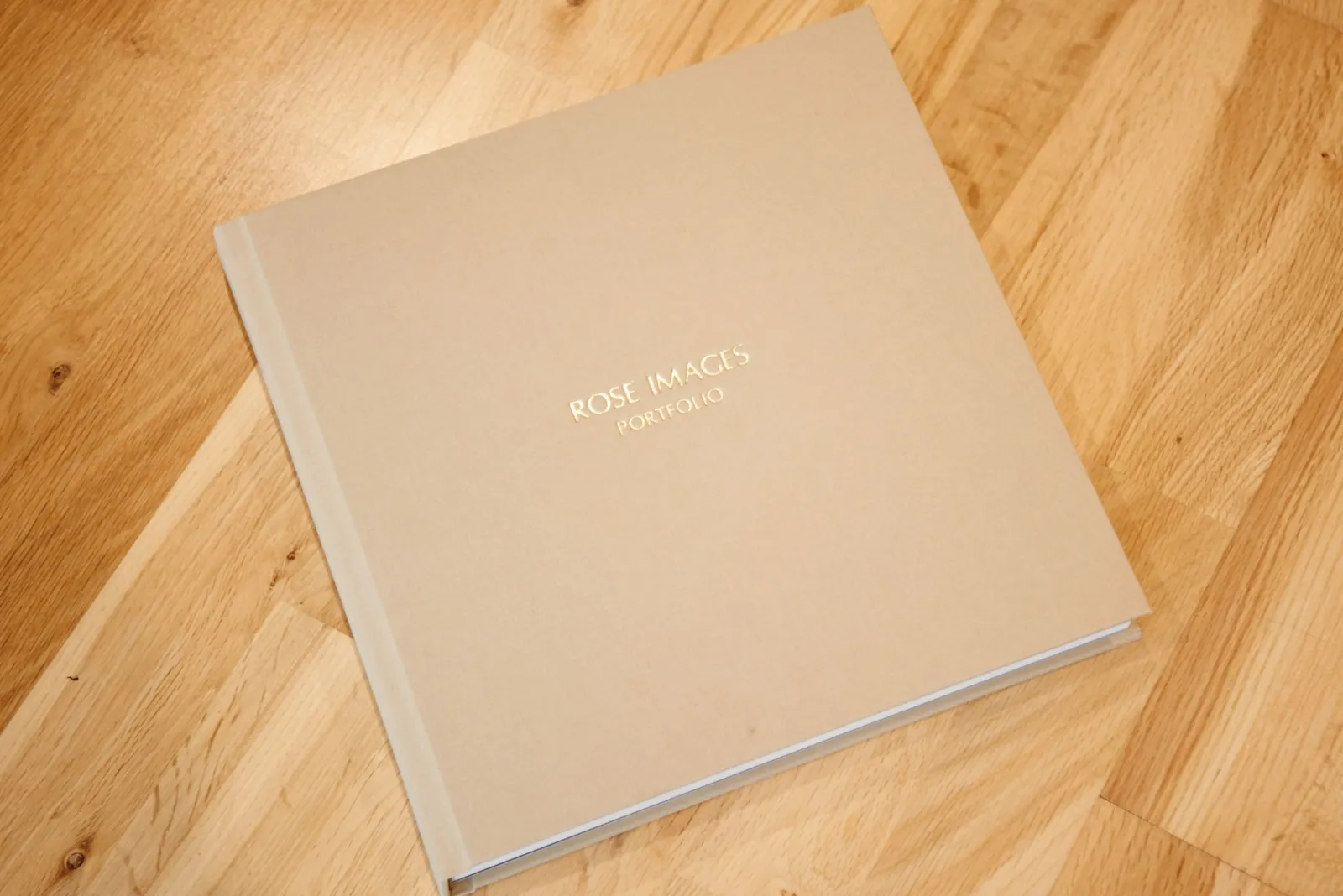 gold fabric wedding album on wooden floor