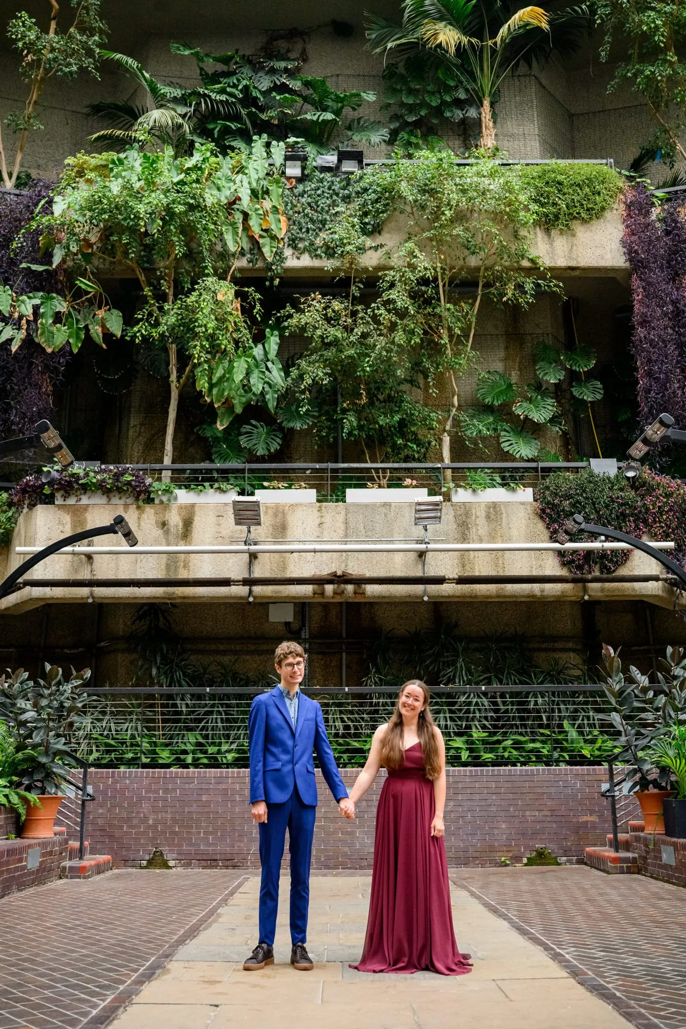 Couple holding hands during engagement photoshoot inside The Barbican Conservatory