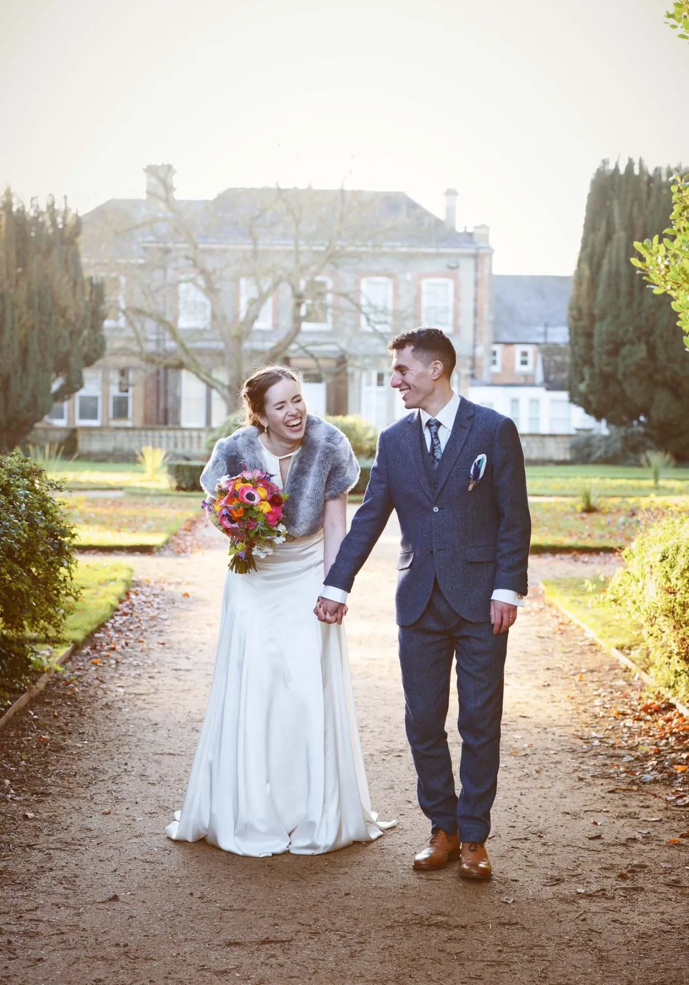 Bride and groom laughing together whilst walking during frosty morning