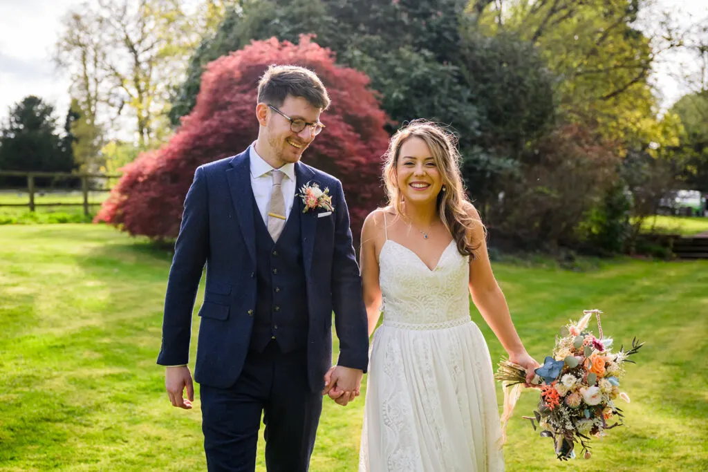 woodborough hall wedding photography bride and groom walking in the gardens