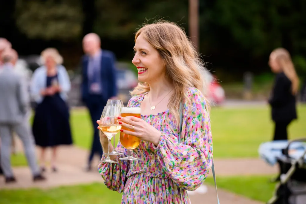 wedding guest enjoying drinks reception outside woodborough hall