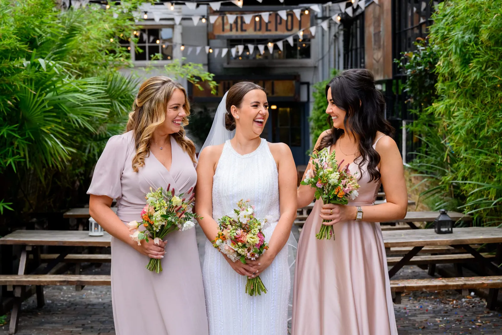 fun photography of bridesmaids laughing in the courtyard at the Depot N7