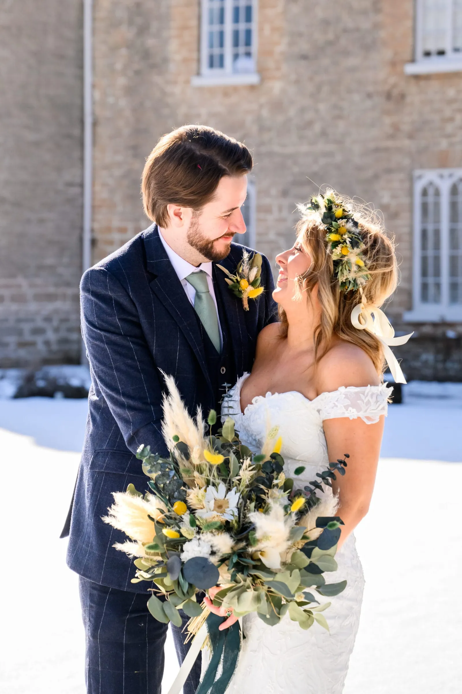 bride and groom laughing on snowy day in front of cockliffe country house