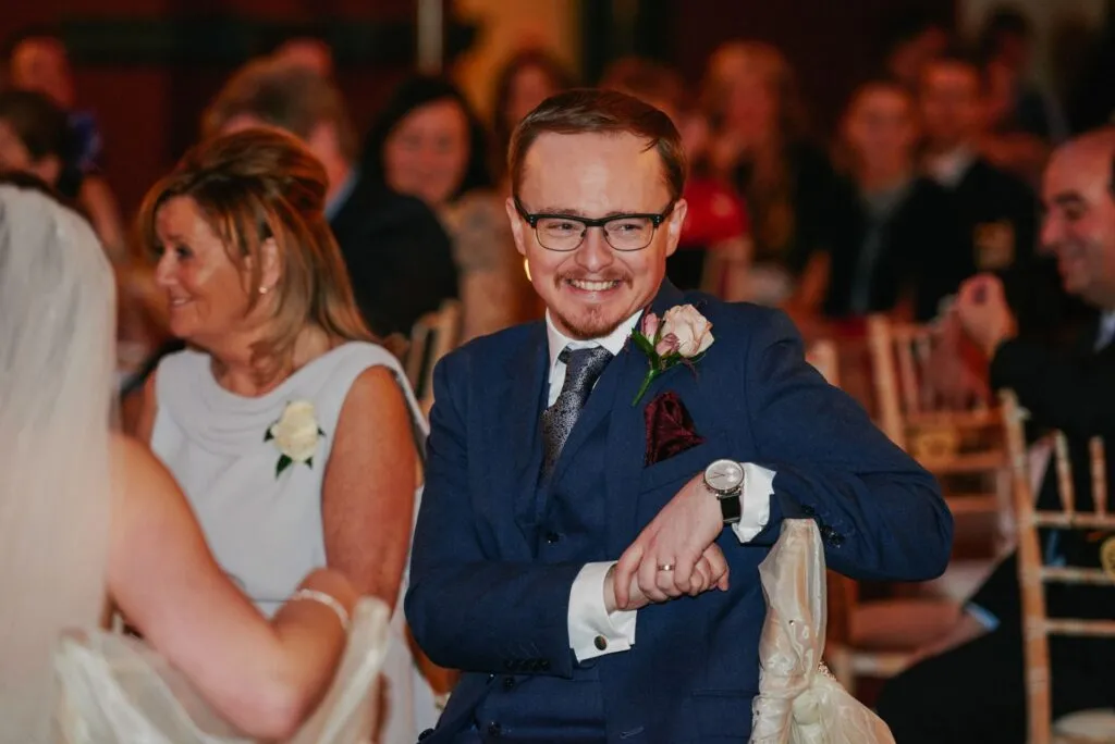 Groom laughing during speeches at fun winter wedding