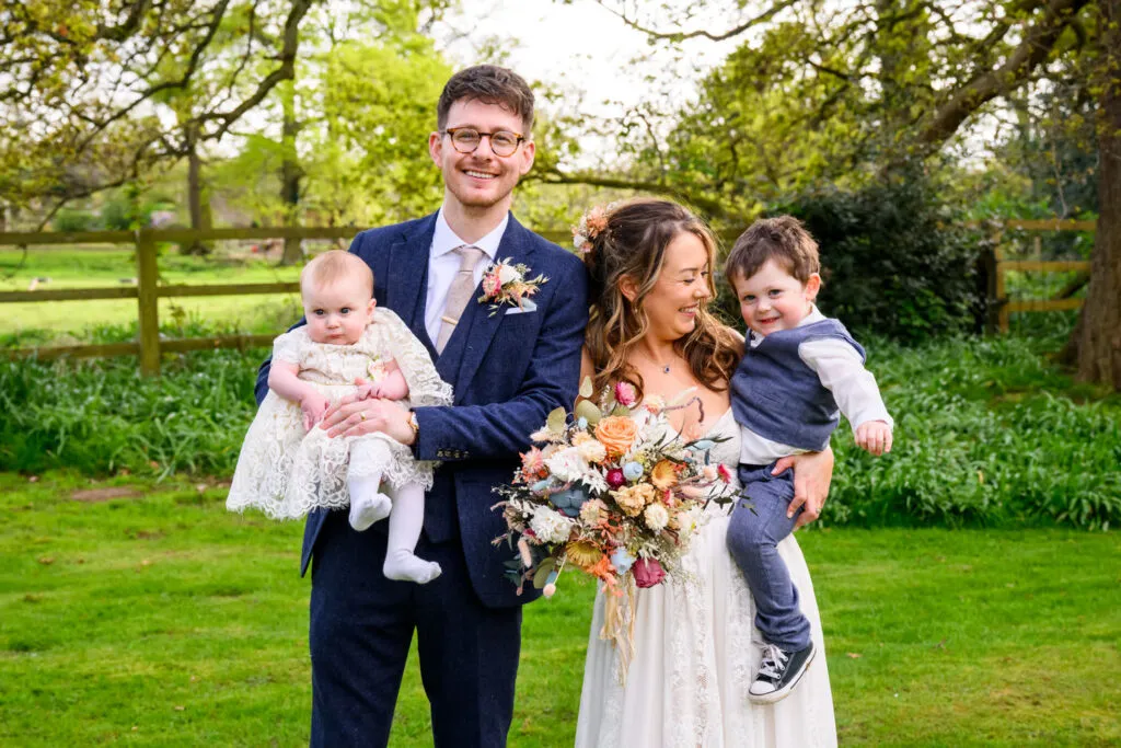 bride and groom with children during woodborough hall wedding family portrait