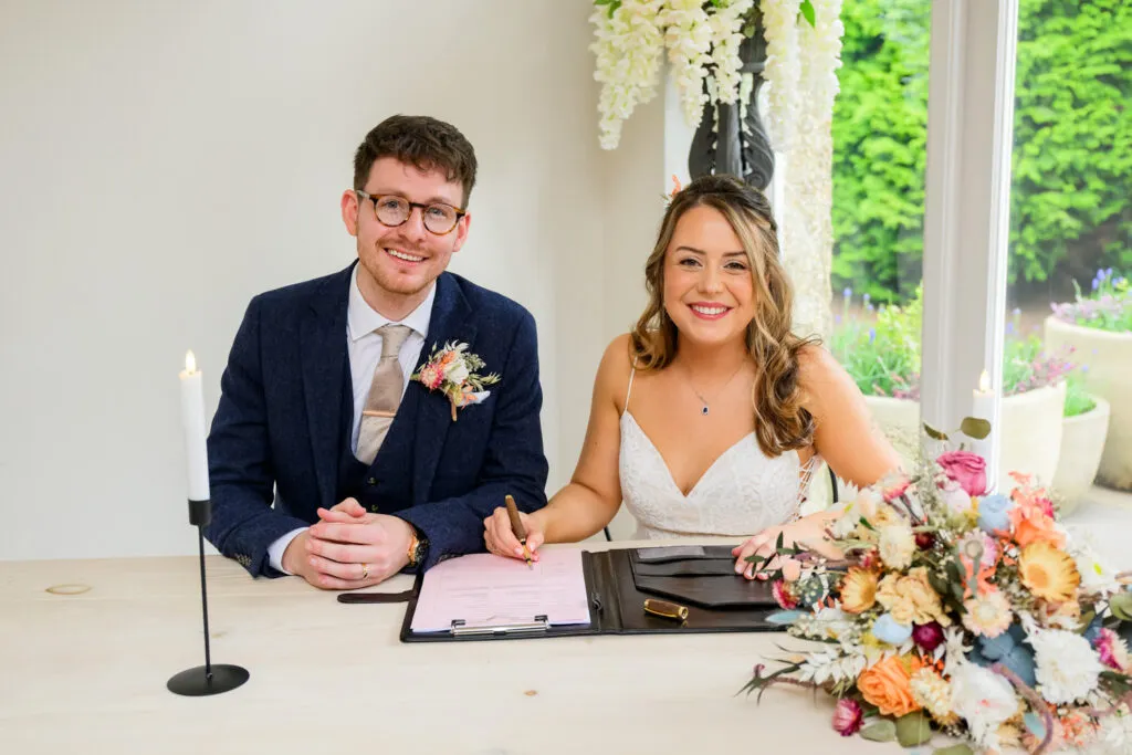 couple signing marriage register at woodborough hall wedding