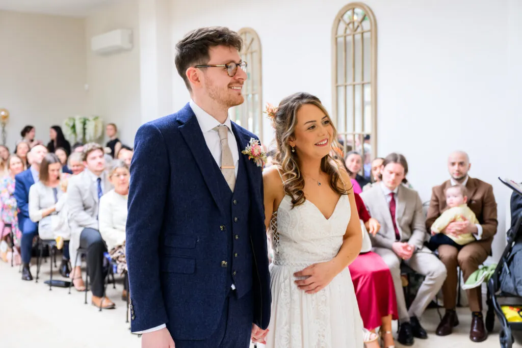 bride and groom standing together during orangery ceremony at woodborough hall wedding