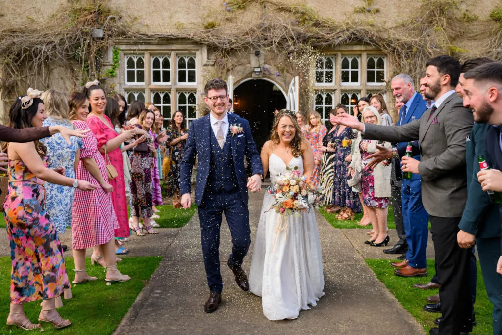 guests throwing confetti outside woodborough hall wedding photography