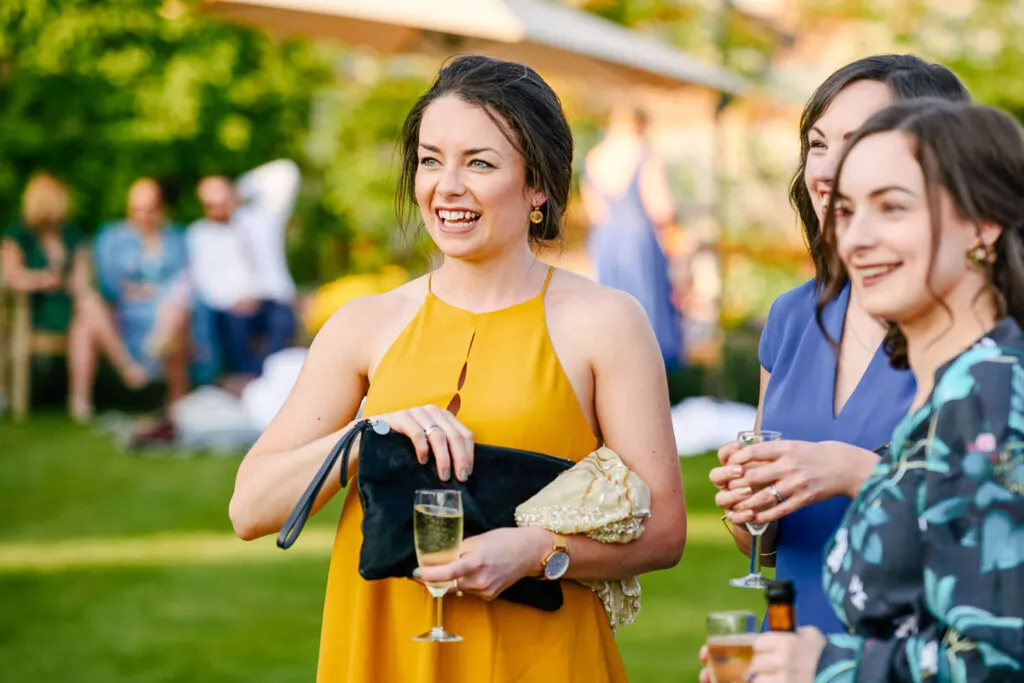 Candid photo of guest smiling during summer wedding at pippley walled garden