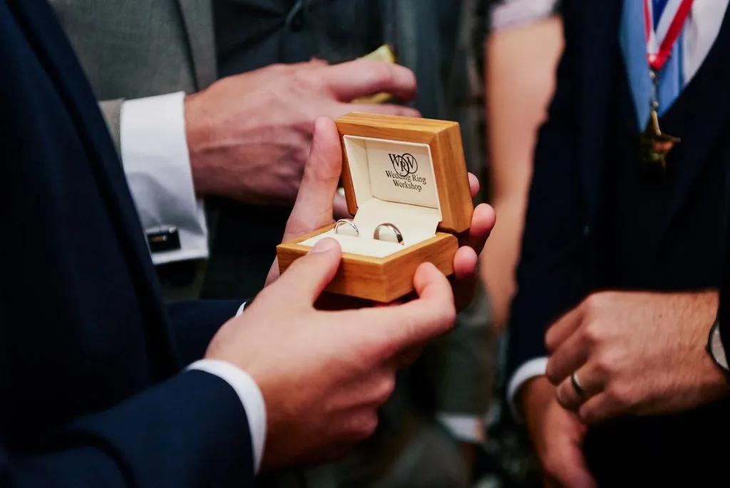 Best man holding wedding rings in box
